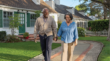 man and woman holding hands while walking